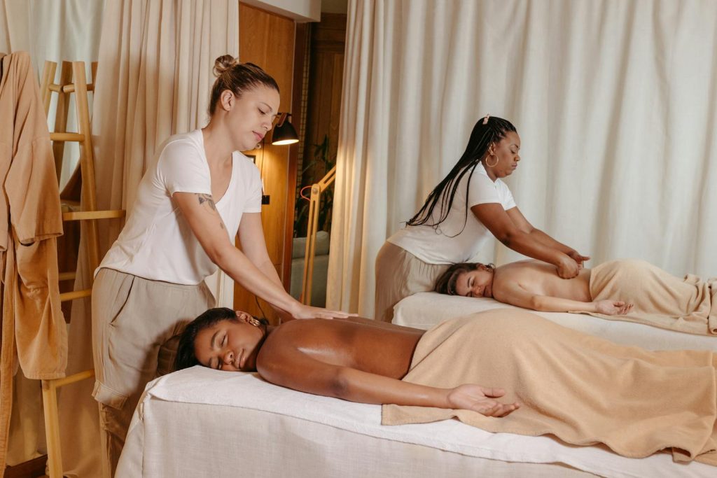 Two women receiving relaxing massages in a serene spa setting, enhancing wellness.